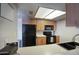 Efficient kitchen features black appliances, light cabinetry, a dual bowl sink, and bright, recessed lighting at 17032 N 16Th Dr # 8, Phoenix, AZ 85023