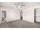 Spacious carpeted bedroom with a ceiling fan, and en-suite bathroom and closet entrances at 19031 N 13Th Dr, Phoenix, AZ 85027
