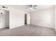 Carpeted bedroom with a ceiling fan, closet, and view into the adjoining bathroom at 19031 N 13Th Dr, Phoenix, AZ 85027