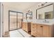 This bathroom has dual sinks with a mirror, a sliding glass door, and a door to the shower at 1955 Leisure World --, Mesa, AZ 85206