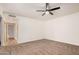 This carpeted bedroom has a ceiling fan with light and leads to a room with light wood floors at 1955 Leisure World --, Mesa, AZ 85206