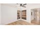 Bright bedroom featuring wood-look floors, two windows, neutral decor, and a ceiling fan at 1955 Leisure World --, Mesa, AZ 85206