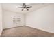 Empty bedroom with neutral carpet, a ceiling fan, and window with wooden shutters at 1955 Leisure World --, Mesa, AZ 85206