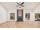 Bright and spacious living room featuring a modern ceiling fan, elegant fireplace, and wood-look flooring at 1955 Leisure World --, Mesa, AZ 85206