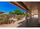 Inviting covered patio with pillars, showcasing a serene view of the landscaped backyard at 1955 Leisure World --, Mesa, AZ 85206