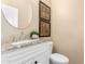 Elegant bathroom with a decorative granite countertop vanity, framed art, and a matching circular framed mirror at 1963 E Monterey St, Chandler, AZ 85225