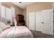 Comfortable bedroom with a window and carpeted floors featuring a bed with light pink bedding and sliding closet doors at 1963 E Monterey St, Chandler, AZ 85225