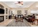 Cozy living room with brown leather sofas, decorative rug, fireplace, and ceiling fan at 1963 E Monterey St, Chandler, AZ 85225
