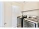 Laundry room features a full-sized washer and dryer set with shelving above at 215 W Mountain Sage Dr, Phoenix, AZ 85045