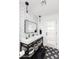 Modern bathroom showcases a sleek sink with storage, black fixtures, and stylish black and white tile flooring at 222 E Danbury Rd, Phoenix, AZ 85022