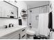 Chic bathroom features a shower with a shower curtain, a vanity, and black and white tiling at 222 E Danbury Rd, Phoenix, AZ 85022