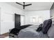 Bright main bedroom with dark wood-look accent wall, fan, and gray upholstered bed with gray bedding at 222 E Danbury Rd, Phoenix, AZ 85022