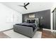 Modern main bedroom with stylish gray upholstered bed, dark accent wall, and wood-look flooring at 222 E Danbury Rd, Phoenix, AZ 85022