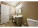 Stylish bathroom featuring a farmhouse sink, rustic vanity, and modern lighting fixtures at 22364 N 59Th Ln, Glendale, AZ 85310
