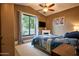 Cozy bedroom with natural light, vaulted ceiling, ceiling fan, and a decorative fireplace below the flat screen tv at 22364 N 59Th Ln, Glendale, AZ 85310