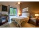 Comfortable bedroom with a decorative fireplace, neutral tones, and a large window for natural light at 22364 N 59Th Ln, Glendale, AZ 85310
