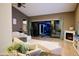 Spacious living room with light hardwood floors, modern fireplace, and sliding glass doors to pool and landscaped backyard at 22364 N 59Th Ln, Glendale, AZ 85310