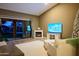 A modern living room with fireplace, hardwood floors, and outdoor access to a pool patio with beautiful backyard views at 22364 N 59Th Ln, Glendale, AZ 85310