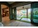 View from indoors, showcasing open sliding glass doors leading to a covered patio and pool area at 22364 N 59Th Ln, Glendale, AZ 85310