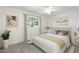 Bright and airy bedroom featuring a ceiling fan, plush carpet, a window with trees, and soft neutral decor at 2261 E Decatur St, Mesa, AZ 85213
