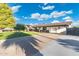 Long driveway with a cozy home features a well-manicured lawn and covered parking at 2261 E Decatur St, Mesa, AZ 85213