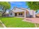 An inviting outdoor space with a covered patio, lush lawn, and a brick fire pit area perfect for entertaining at 2620 E Rustling Oaks Ln, Phoenix, AZ 85024