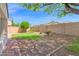 View of backyard with a brick-lined border, showcasing a low-maintenance landscape with small palms and verdant grass at 2620 E Rustling Oaks Ln, Phoenix, AZ 85024