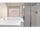 Bathroom features a luxurious soaking tub, glass-enclosed shower, and window with natural light at 2620 E Rustling Oaks Ln, Phoenix, AZ 85024