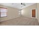Bright bedroom features neutral carpet, ceiling fan, and door leading to outdoor space at 2620 E Rustling Oaks Ln, Phoenix, AZ 85024