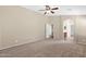 Spacious bedroom with neutral carpet, ceiling fan, and view to the en-suite bathroom at 2620 E Rustling Oaks Ln, Phoenix, AZ 85024