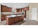 Kitchen with central island, granite countertops, dark wood cabinetry, stainless steel appliances, and tile flooring at 2620 E Rustling Oaks Ln, Phoenix, AZ 85024