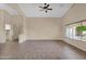 Open and bright living area with tile flooring, neutral paint, a ceiling fan, and large windows for natural light at 2620 E Rustling Oaks Ln, Phoenix, AZ 85024
