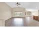 Open-concept living room with neutral walls, vaulted ceiling, fan, tile floors, and large windows at 2620 E Rustling Oaks Ln, Phoenix, AZ 85024