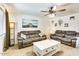 Inviting living room with plush sofas, coffee table, ceiling fan, and natural light at 3553 W El Camino Dr, Phoenix, AZ 85051