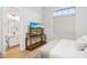 Bright bedroom with a TV stand, a view through a window, and an ensuite bathroom at 4024 E Minton Cir, Mesa, AZ 85215