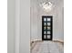 Bright entryway featuring hardwood floors, a modern chandelier, and a black framed front door at 4024 E Minton Cir, Mesa, AZ 85215