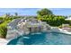 Resort-style pool with rock waterfall and slide, surrounded by lush landscaping, offering a fun outdoor oasis at 4024 E Minton Cir, Mesa, AZ 85215