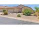 Desert landscaped front yard with a stucco home, 2-car garage, and wrought iron gate at 4611 E Night Glow Dr, Cave Creek, AZ 85331