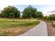 Lush community park with mature trees, walking path, and rock landscaping at 5328 S Wesley Cir, Mesa, AZ 85212