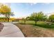Beautifully landscaped community park with walking path, bench, and mature shade trees at 5328 S Wesley Cir, Mesa, AZ 85212