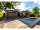 A beautifully designed home with a three-car garage, stone accents, and lush desert landscaping at 5328 S Wesley Cir, Mesa, AZ 85212