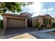 Inviting home exterior showcasing a three-car garage, stone details, and manicured desert landscaping at 5328 S Wesley Cir, Mesa, AZ 85212