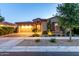 Charming single-Gathering home featuring a stone facade, a two-car garage, and well-maintained landscaping at twilight at 5328 S Wesley Cir, Mesa, AZ 85212