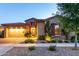Charming single-Gathering home featuring a stone facade, a two-car garage, and well-maintained landscaping at twilight at 5328 S Wesley Cir, Mesa, AZ 85212
