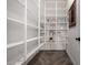 Well-organized pantry with ample shelving space for all your storage needs and dark wood-look floors at 5328 S Wesley Cir, Mesa, AZ 85212