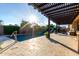 Sparkling swimming pool featuring travertine tile and a wooden pergola providing shade for outdoor lounging at 5328 S Wesley Cir, Mesa, AZ 85212