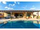 Backyard featuring a private swimming pool, travertine patio, covered outdoor kitchen, and cozy seating area at 5328 S Wesley Cir, Mesa, AZ 85212