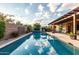 Backyard swimming pool with clear blue water, a cozy patio, and lush green landscaping at 5328 S Wesley Cir, Mesa, AZ 85212