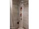 Close-up of an upgraded shower featuring three showerheads, shelving, and sleek tile at 5539 N 31St Ln, Phoenix, AZ 85017