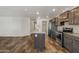 Open concept kitchen with large island, stainless appliances, and wood-look floors at 5601 W Missouri Ave # 150, Glendale, AZ 85301